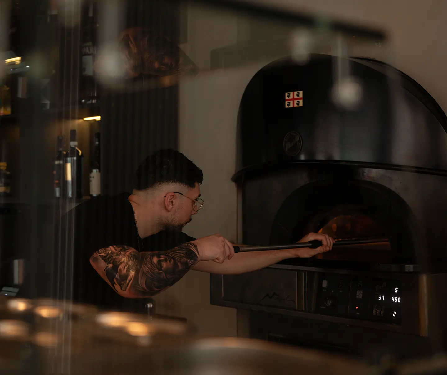 man schiebt pizza in den ofen