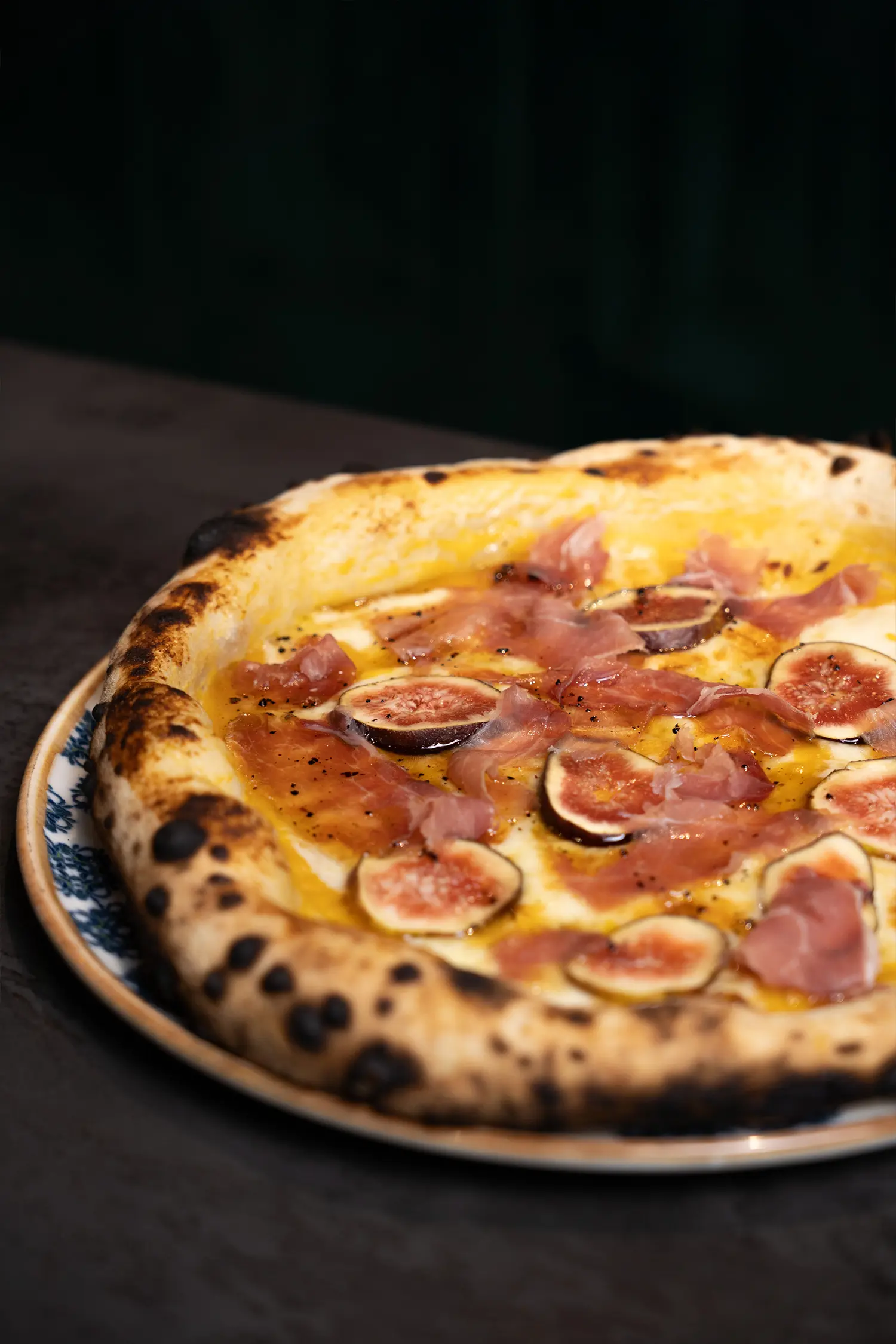 Fuenfneunzwei-modern-italian-galerie-bild-6 a pizza with figs and cheese on a plate